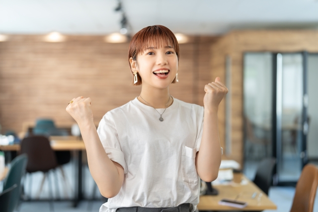 ガッツポーズをする若いビジネスウーマン