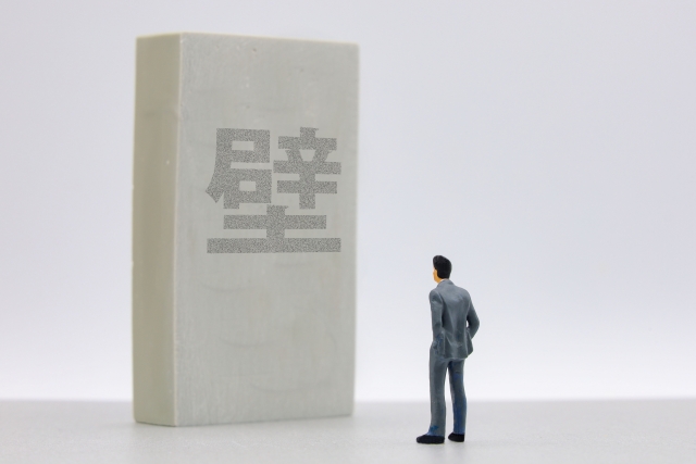 壁の前に立つビジネスマン
