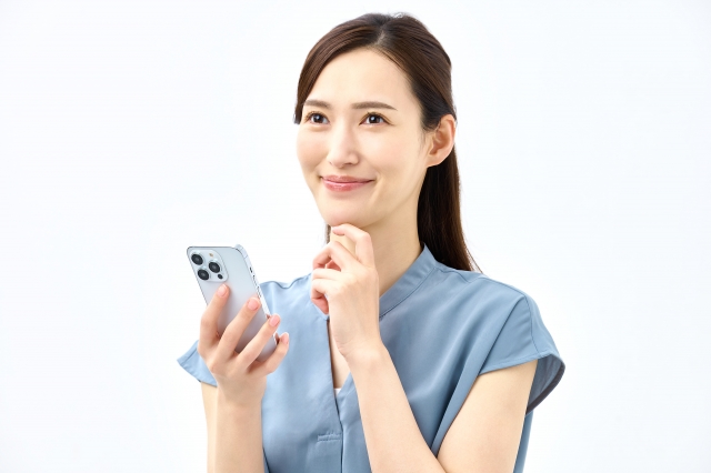 スマホを持ち考える若い女性