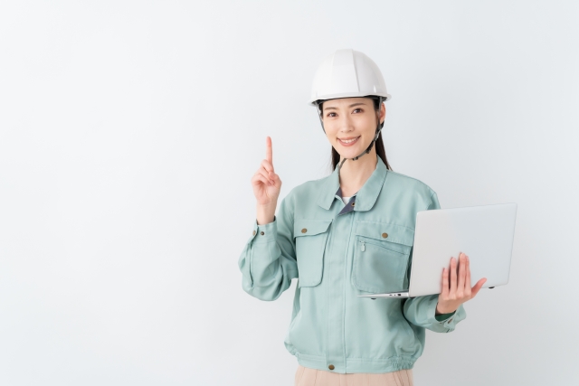 パソコンを持った作業服のビジネスウーマン