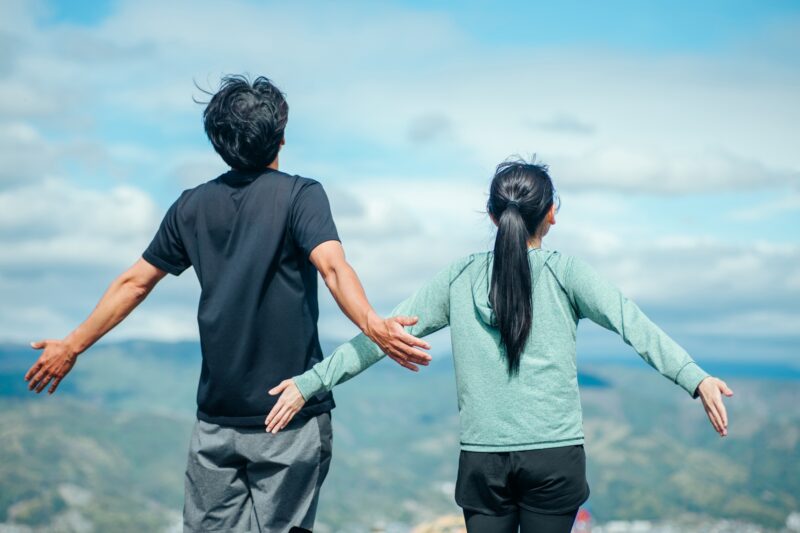 深呼吸する男女の後ろ姿
