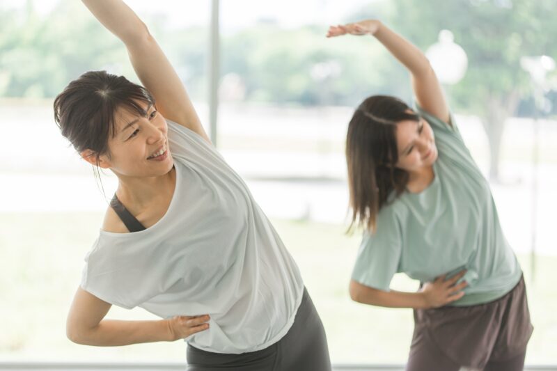 ジムでストレッチ・柔軟体操をする女性