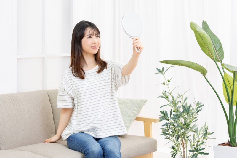 鏡を見て自分の顔をチェックする女性