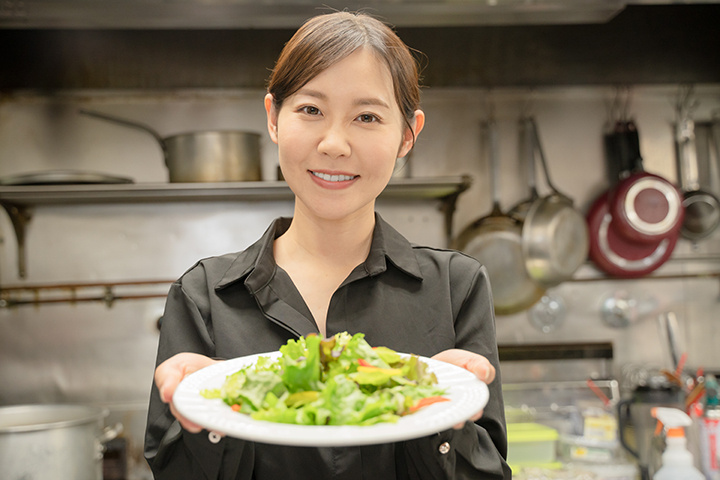 飲食店で料理を提供する女性スタッフ