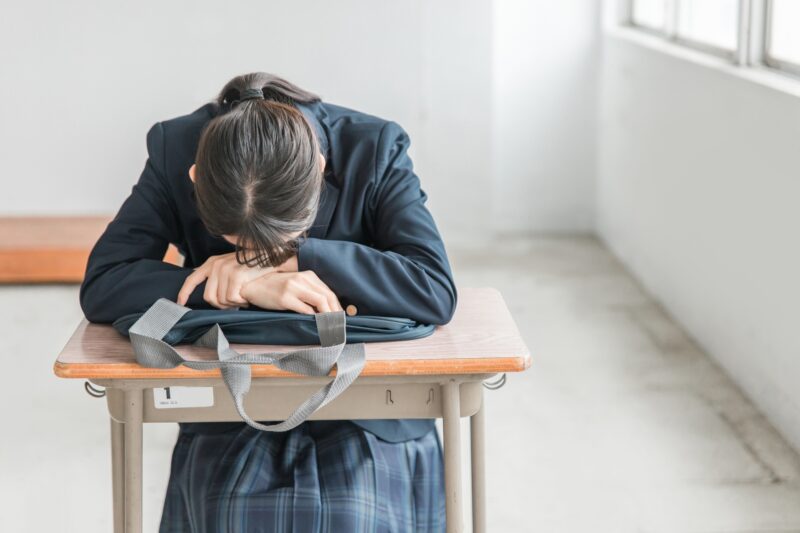 学校の教室で落ち込む女子中学生