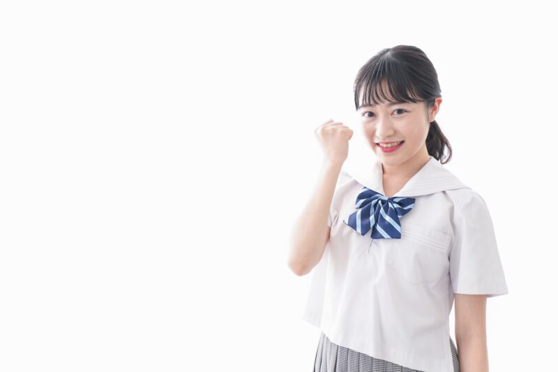 ガッツポーズをする制服姿の学生