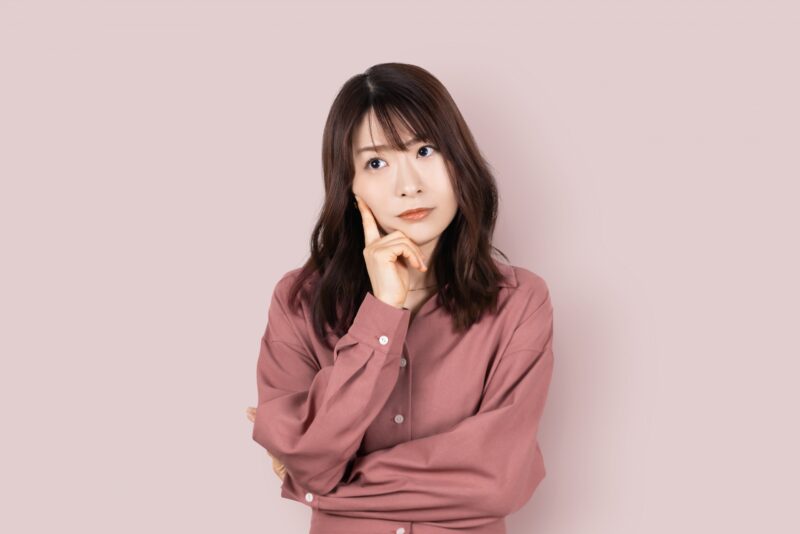 真剣な表情で考えごとをする女性