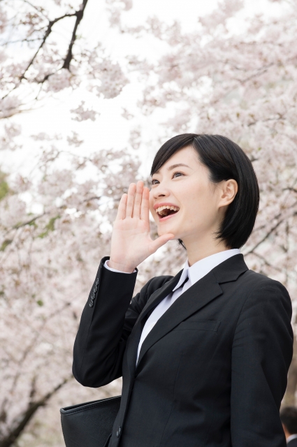 桜と就活生の女性