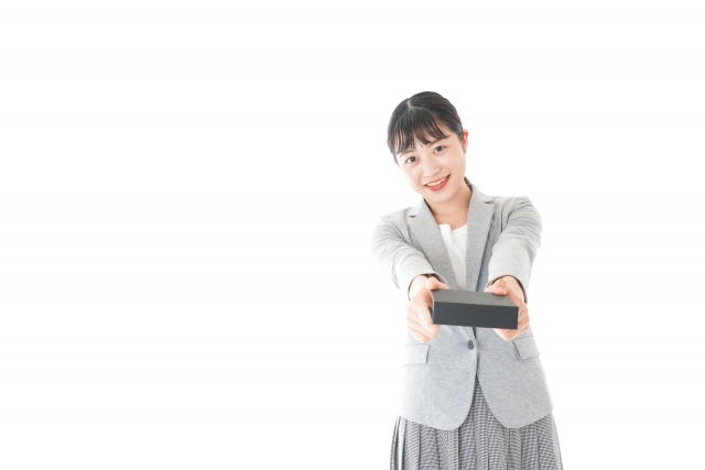 プレゼントを渡す若いビジネスウーマン