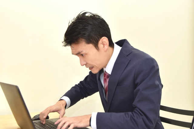焦ってPCを操作する男性