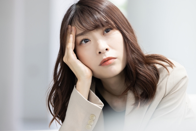 真剣な表情で考えごとをする女性