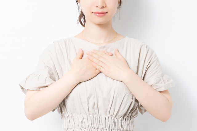胸に手を当てる若い女性