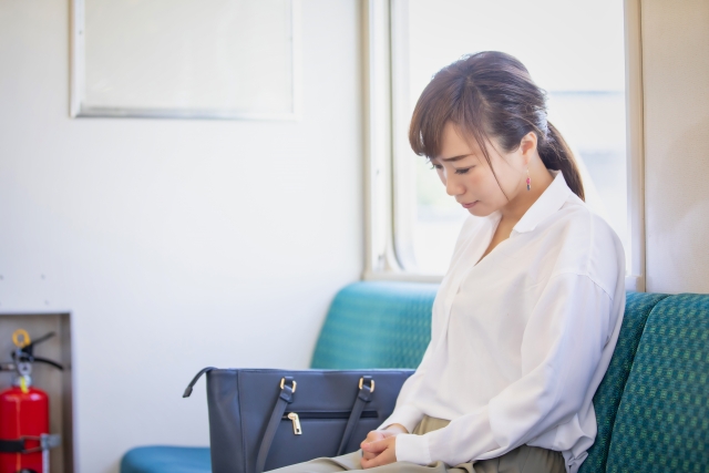 電車で落ち込む女性