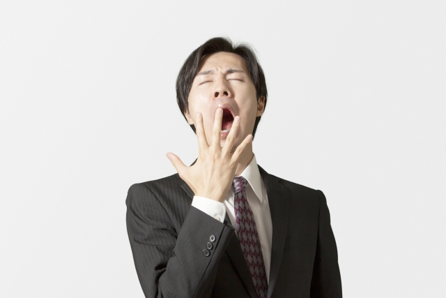 退屈であくびをする男性