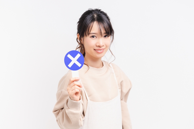 NGのプラカードを持つ若い女性