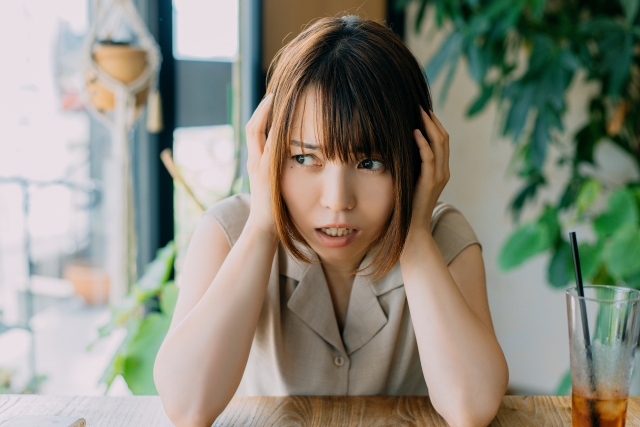 頭を抱えて悩む女性